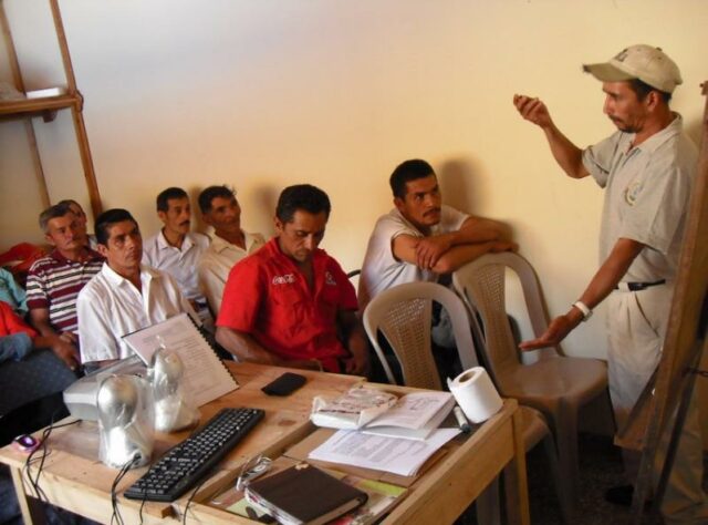 Carlos leads a workshop with a group of farmers