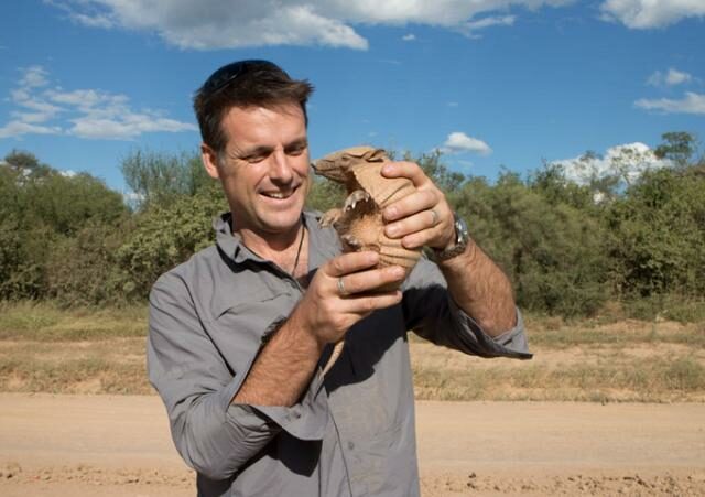 Nick Baker holds up an armadillo.