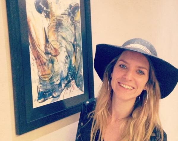 Tori Ratcliffe and one of her paintings of a Rhinoceros.