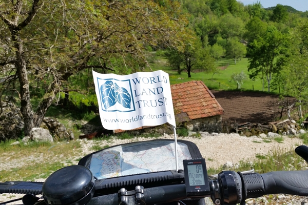 Bike handlebars with World Land Trust flag and map visible
