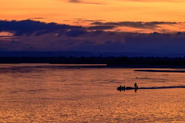 Sunset over the wetlands. The fishers start to bring their boats in for the evening, silhouetted against the rich orange and purple colours of the sky. Credit: FBC