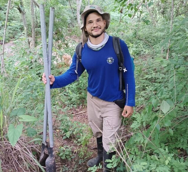 Marcelo stands in the middle of a forest