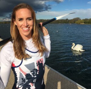 Photograph of Helen Glover rowing with a swan in the background
